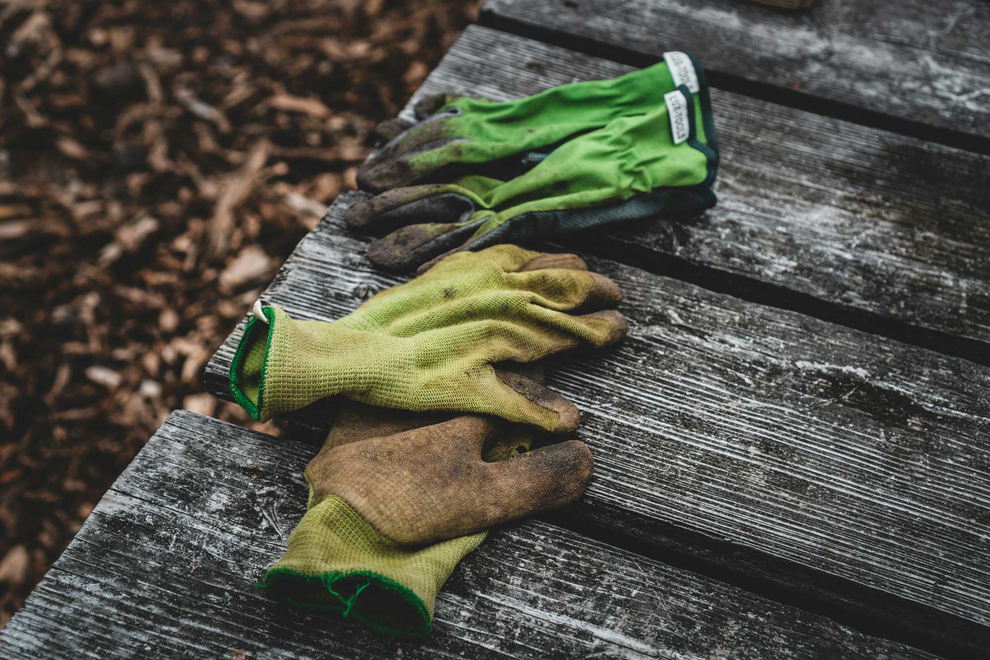 Gartenhandschuhe auf Holzoberfläche.