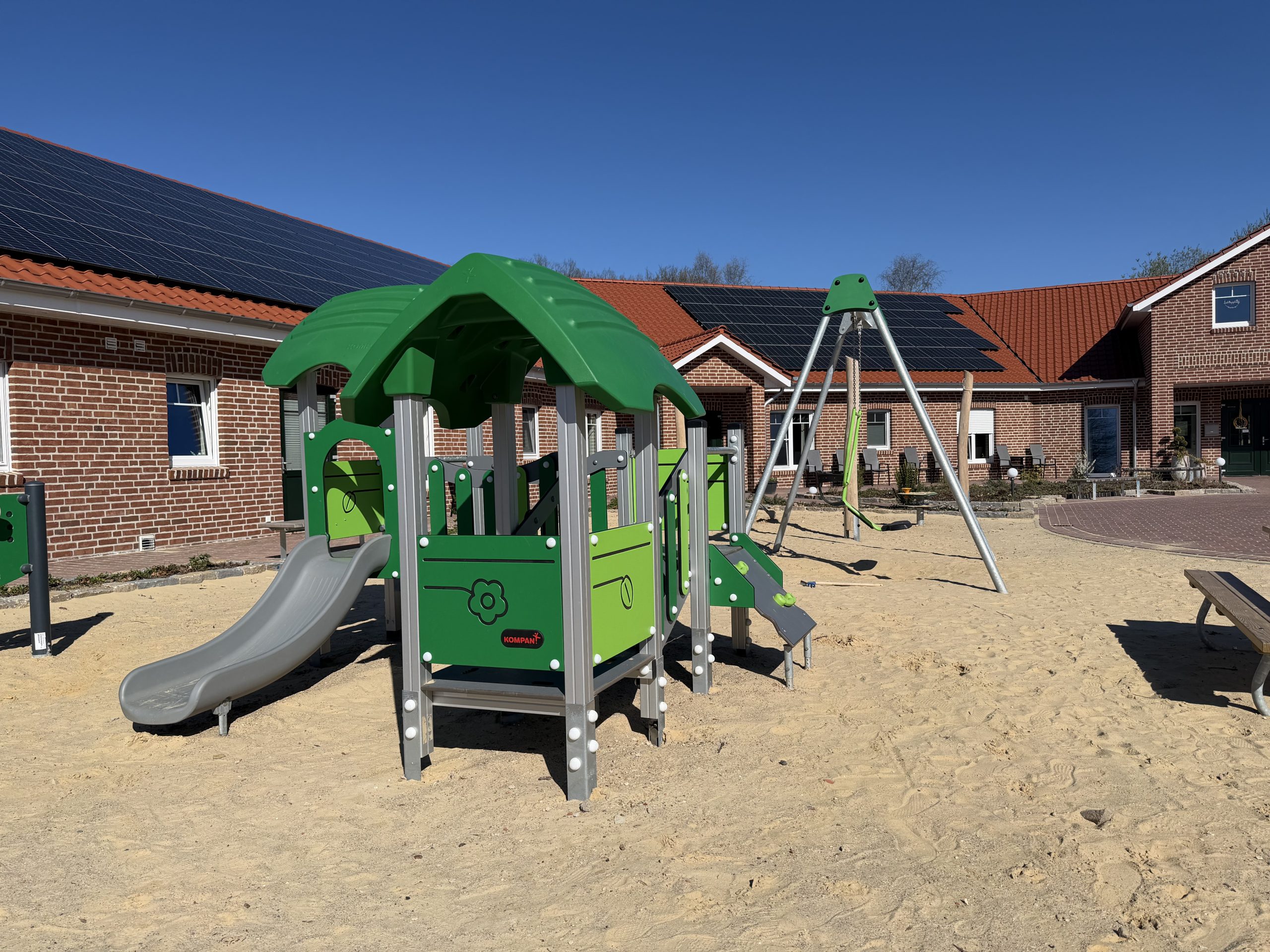 Spielplatz einer Kommune mit großer Sandfläche.