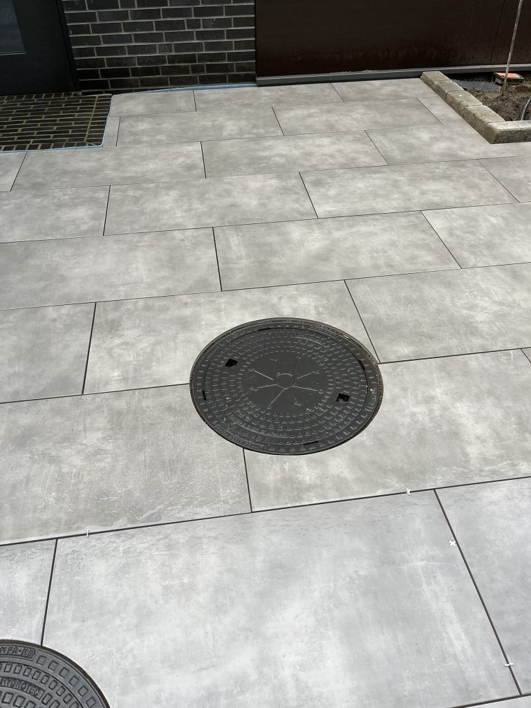 Gefließte Terrasse mit Wasserablauf.